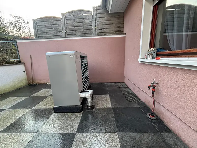 Nameščena toplotna črpalka ob vogalu hiše